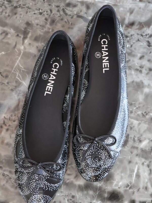 Czarne baleriny Chanel Limited Edition ze srebrzystym wzorem, kokardkami i logo CC na noskach.