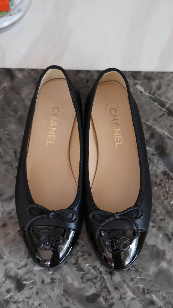 Czarne baleriny Chanel Classic z lakierowanymi noskami, kokardkami i czarnym logo CC.