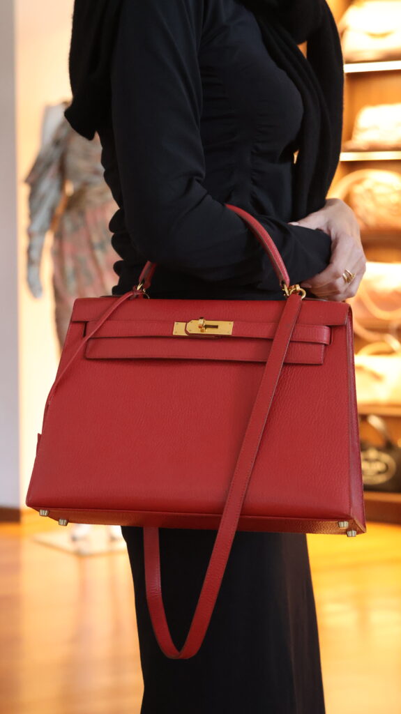 Czerwona torebka Hermès Kelly 32 ze skóry Vachette Ardennes, ze złotym zapięciem, górnym uchwytem i długim paskiem na ramię.