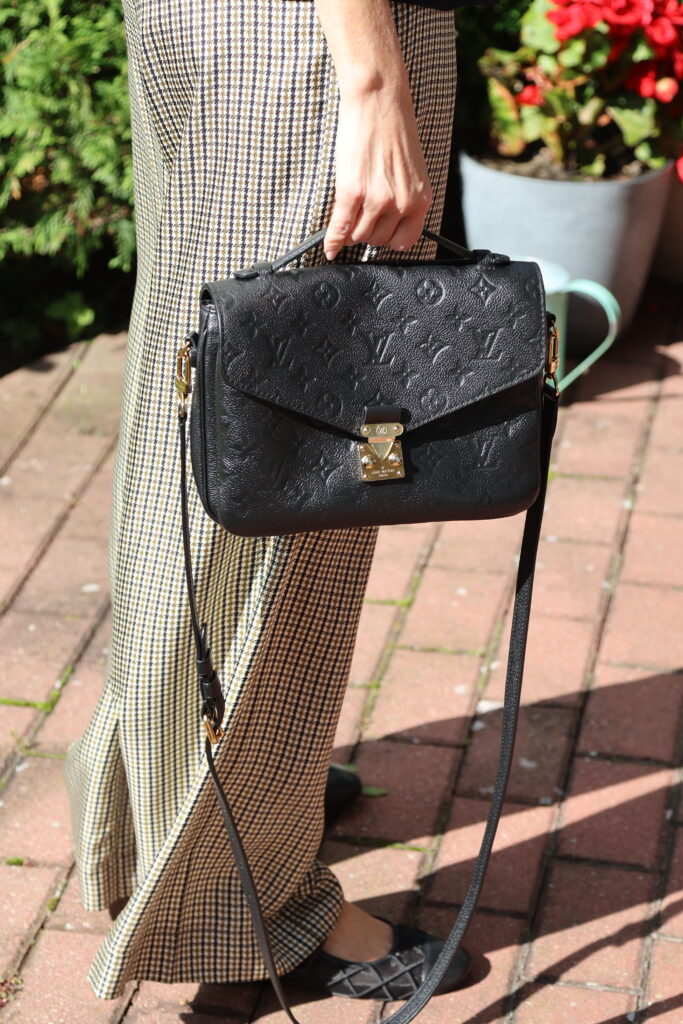 Czarna torebka Louis Vuitton Pochette Métis ze skóry Monogram Empreinte, ze złotym zapięciem, uchwytem i długim paskiem na ramię.
